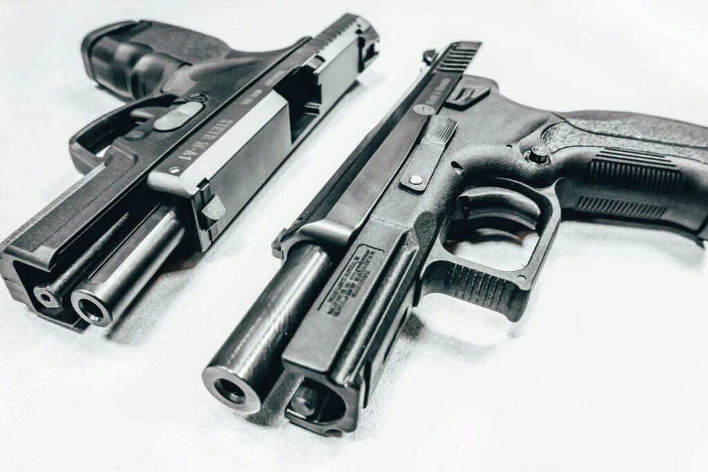 Deux répliques de pistolet d'airsoft posées sur un fond clair